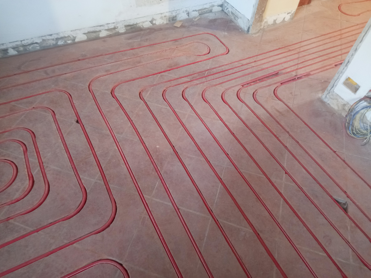 McCandless Plumbing & Excavation installing underfloor heating and working on excavation in a room being renovated.