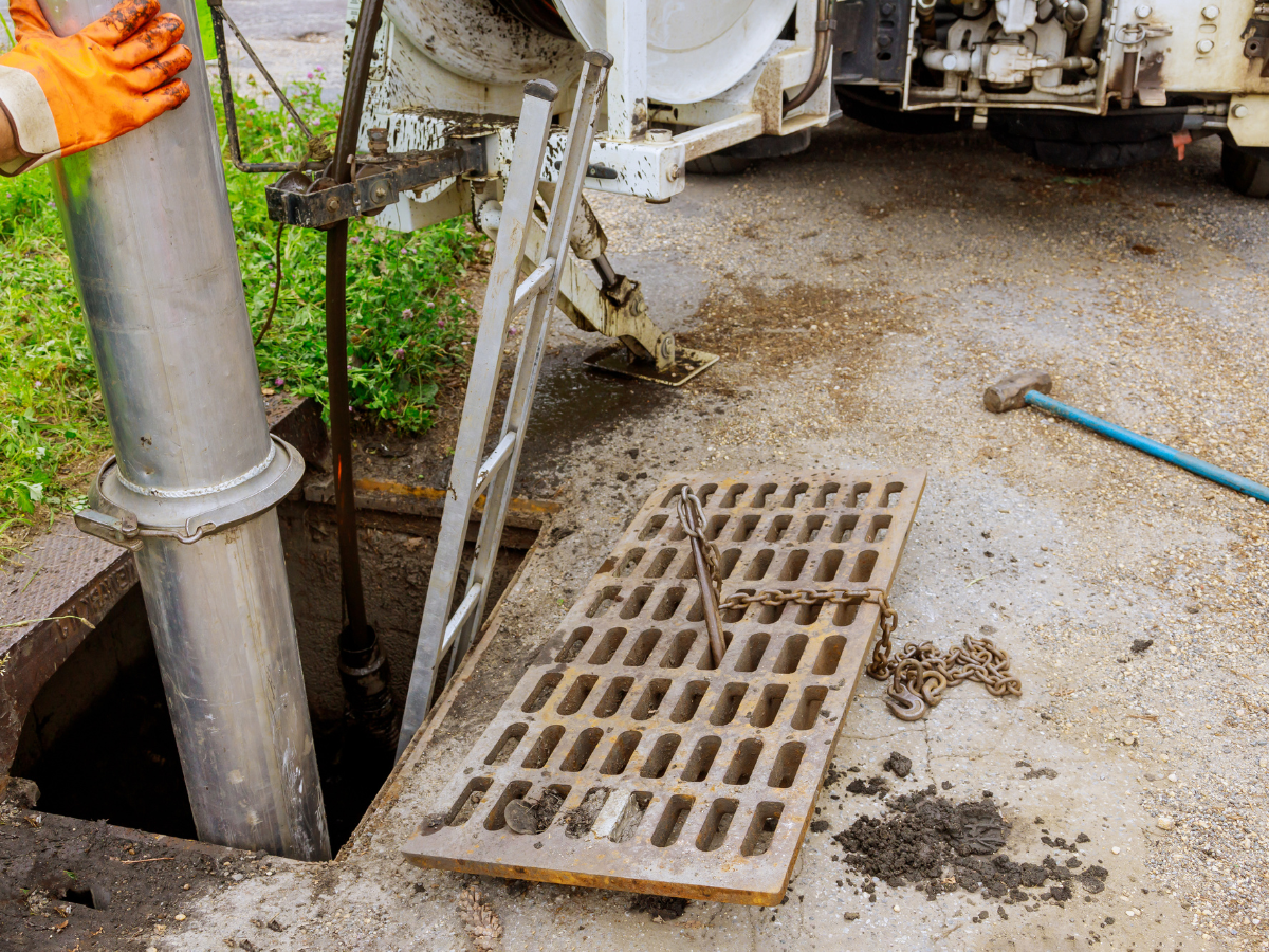 McCandless Plumbing & Excavation worker cleans a drain using equipment to clear blockages and keep sewers flowing properly.