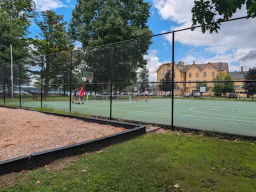 McCandless Plumbing & Excavation helps repair sewers at a busy spot near tennis courts, a playground, and a large building.