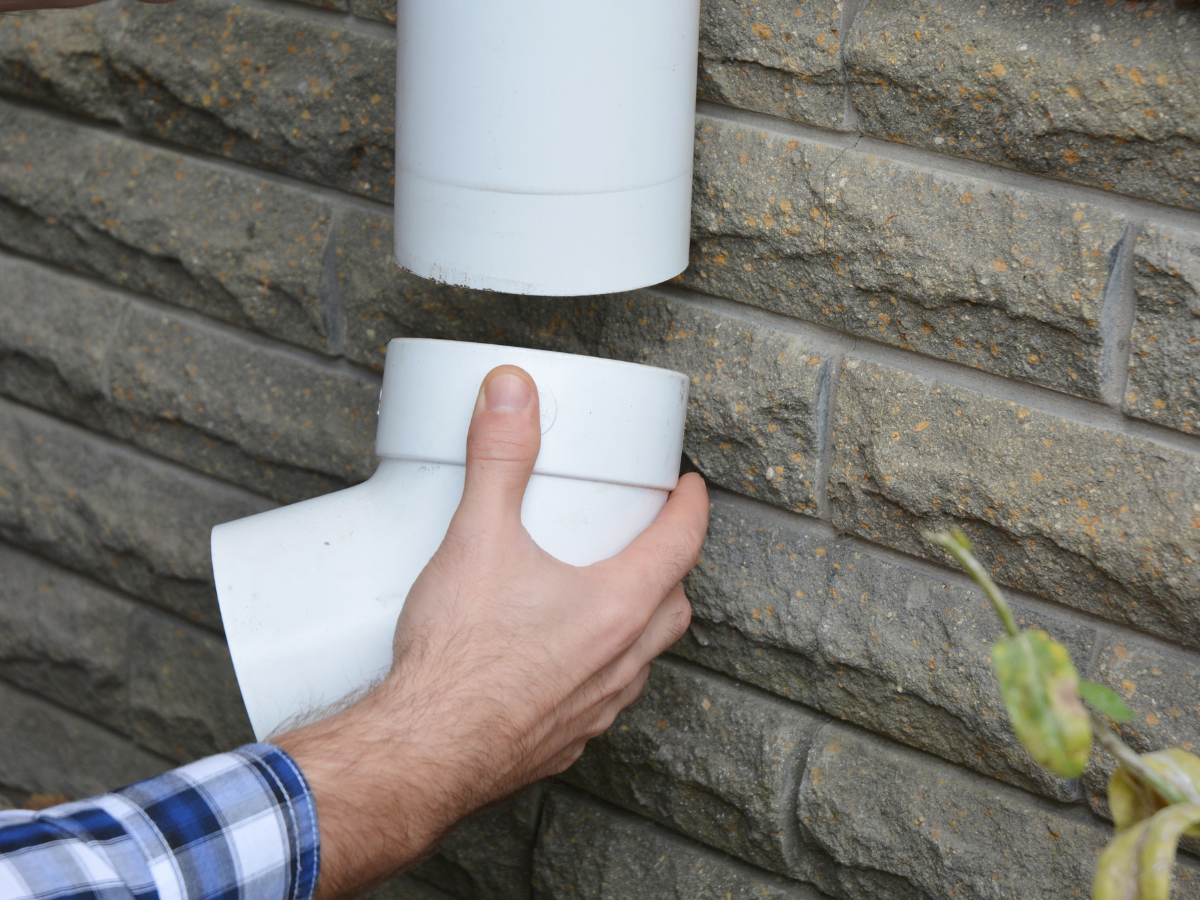 McCandless Plumbing & Excavation worker checks and connects a pipe, getting drainage ready for a possible sewer camera inspection.