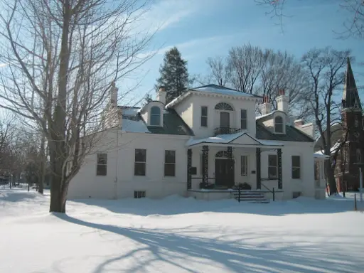 McCandless Plumbing & Excavation prepares for a winter septic check at a home with snow on the ground and roof.