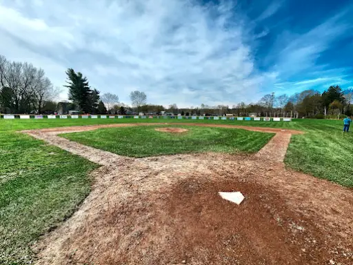 McCandless Plumbing & Excavation crew talks about a field project at a baseball park on a sunny day.