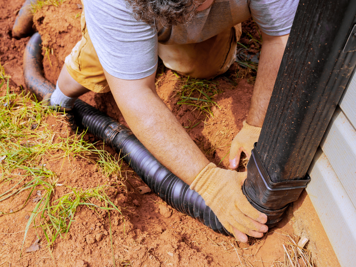 McCandless Plumbing & Excavation connects drainage piping for septic service or repairs near a building.