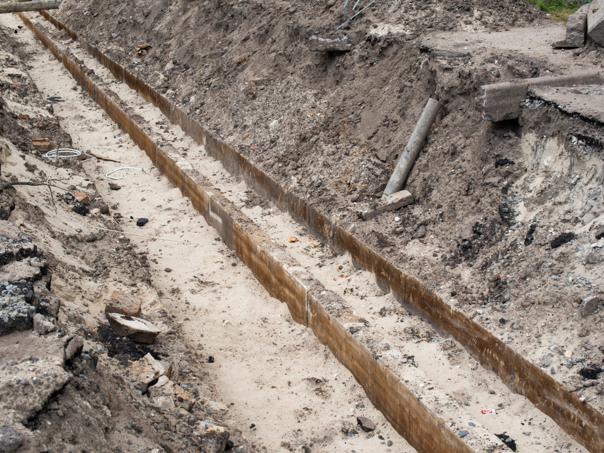 McCandless Plumbing & Excavation repairing underground pipes, showing sewer work and tools at an active job site.