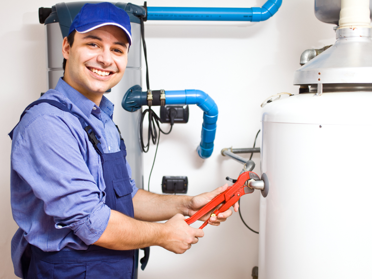 A friendly McCandless Plumbing & Excavation worker fixing a water heater, showing expert service for home repairs.