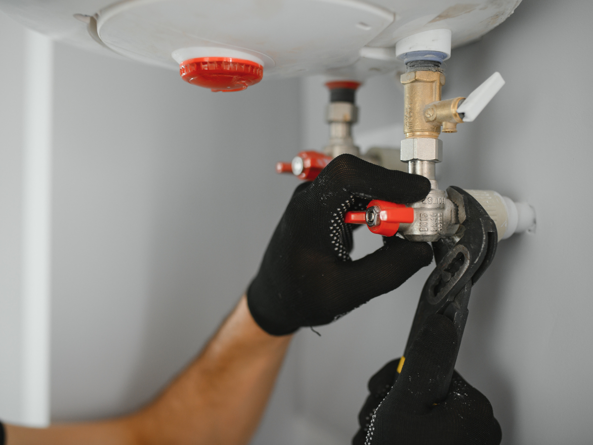 McCandless Plumbing & Excavation technician fixes a water heater valve as part of a plumbing or septic service.