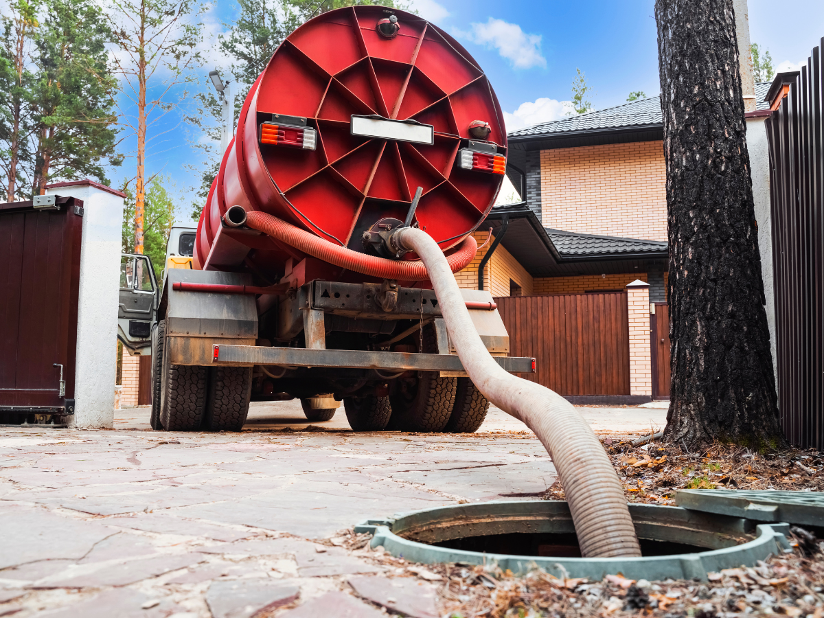 McCandless Plumbing & Excavation provides sewer repair services with a red sewage truck at a customer's home.