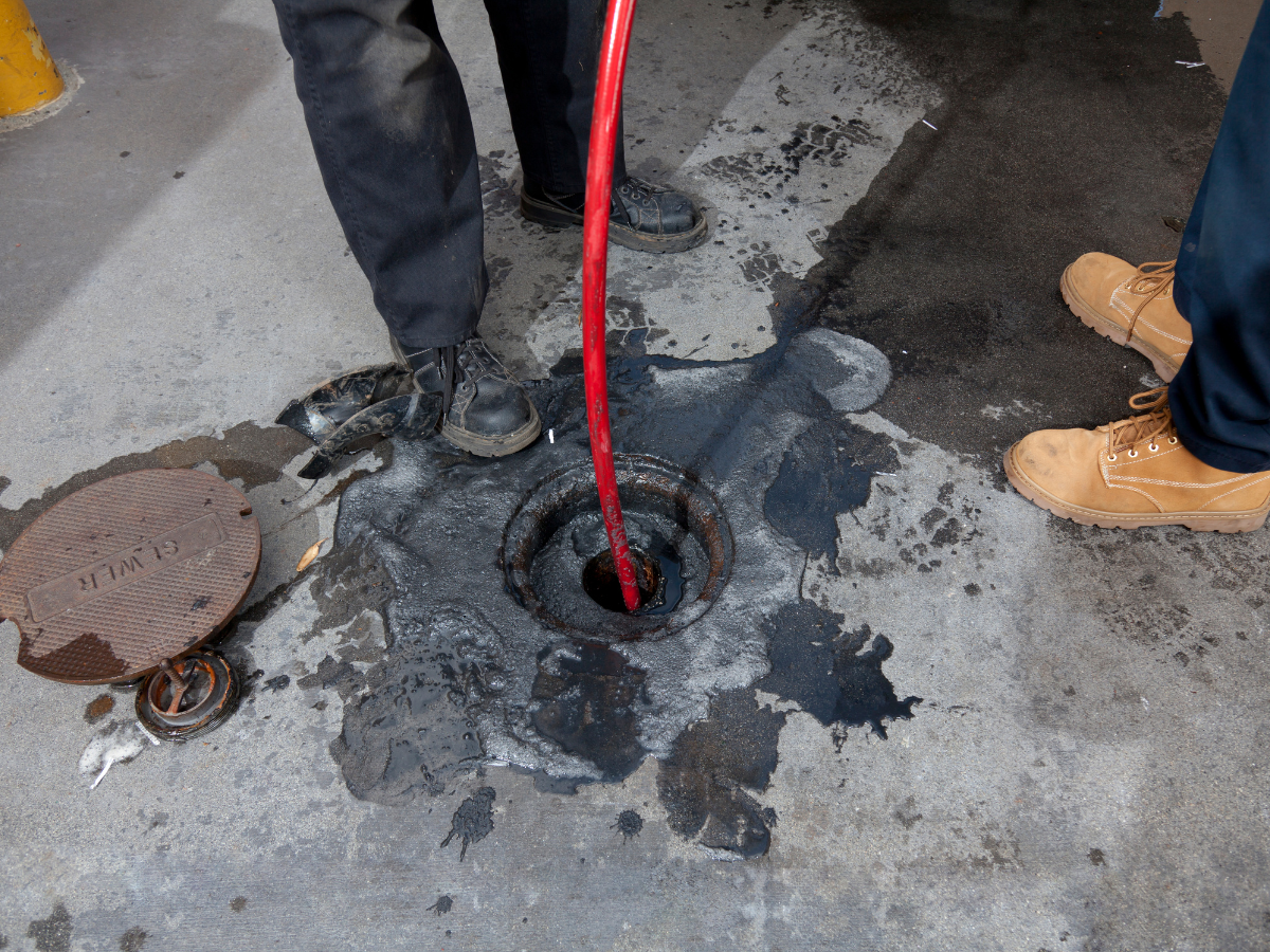 McCandless Plumbing & Excavation workers inspect a manhole, showing a real-life example of sewer repair service in action.