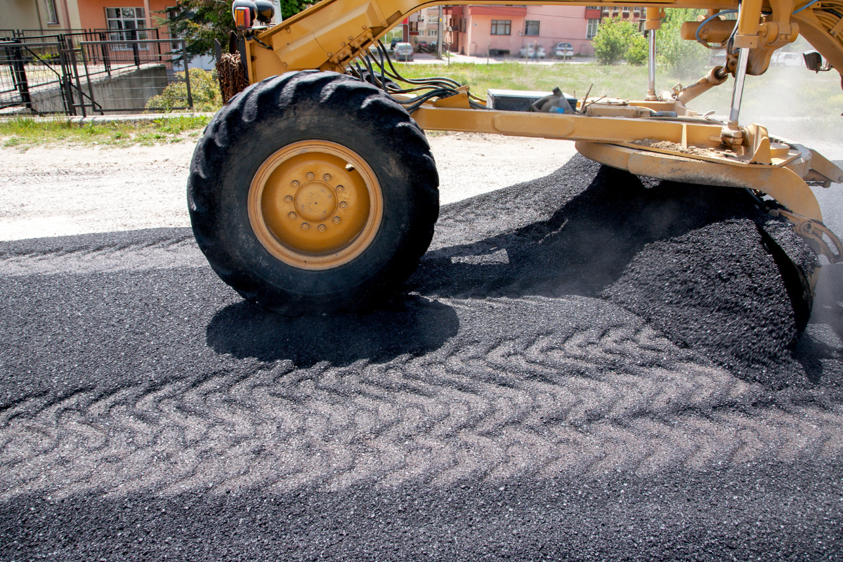 McCandless Plumbing & Excavation uses equipment to smooth new asphalt, showing the clean results similar to hydro jetting.