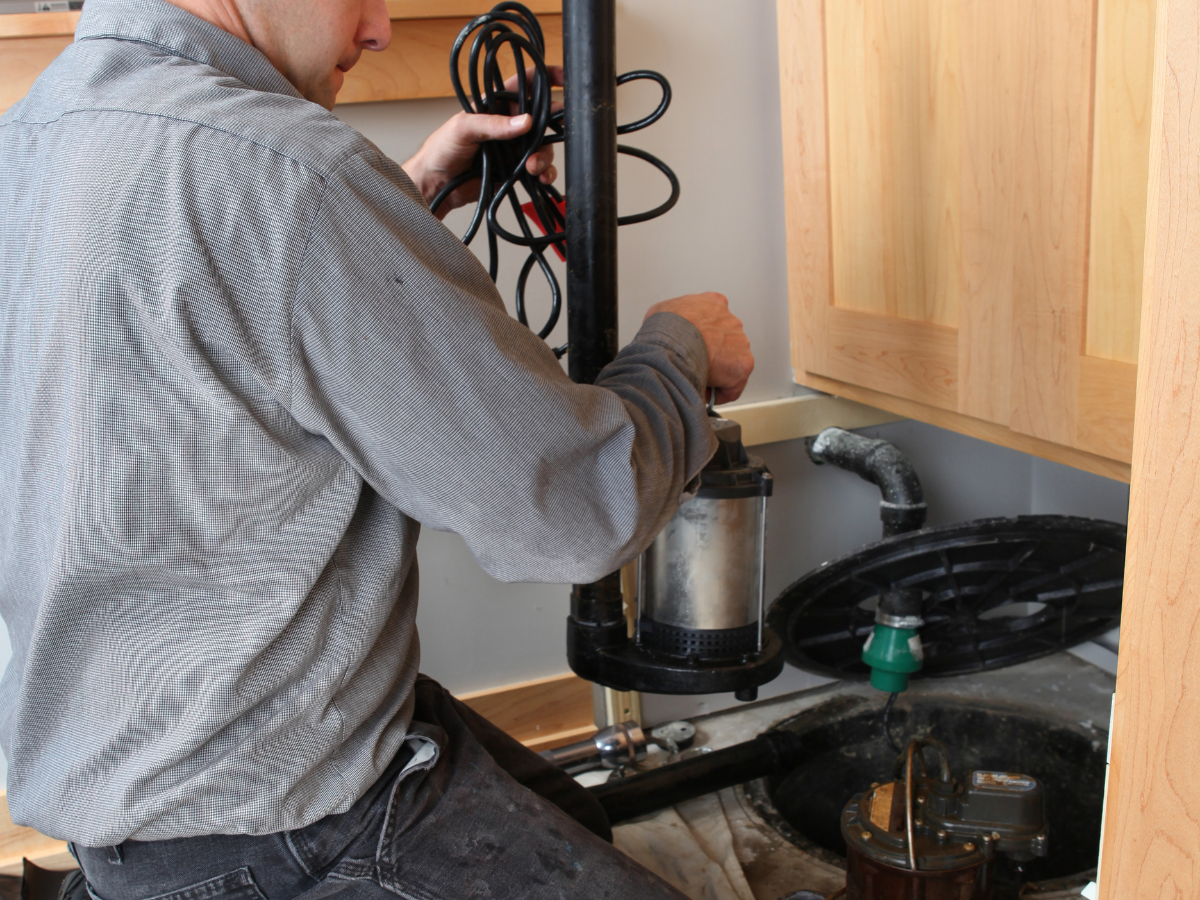 McCandless Plumbing & Excavation technician works on a sump pump during a sewer camera inspection or maintenance.