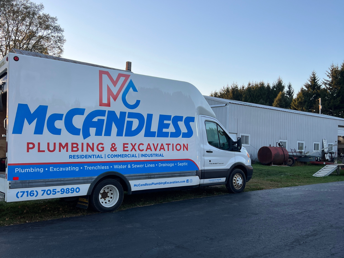 A McCandless Plumbing & Excavation van is ready to help customers at a business location with contact details clearly shown.