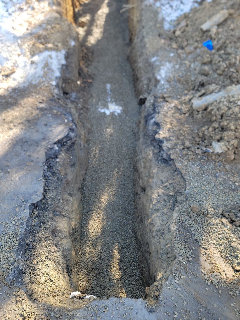 McCandless Plumbing & Excavation prepares a gravel trench, ready for piping in winter ground conditions.