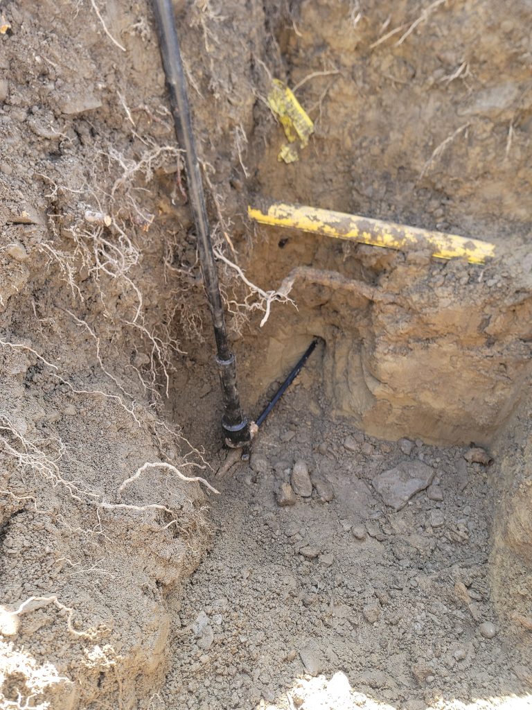 McCandless Plumbing & Excavation shows a pipe and utility marker found during digging to check underground lines.