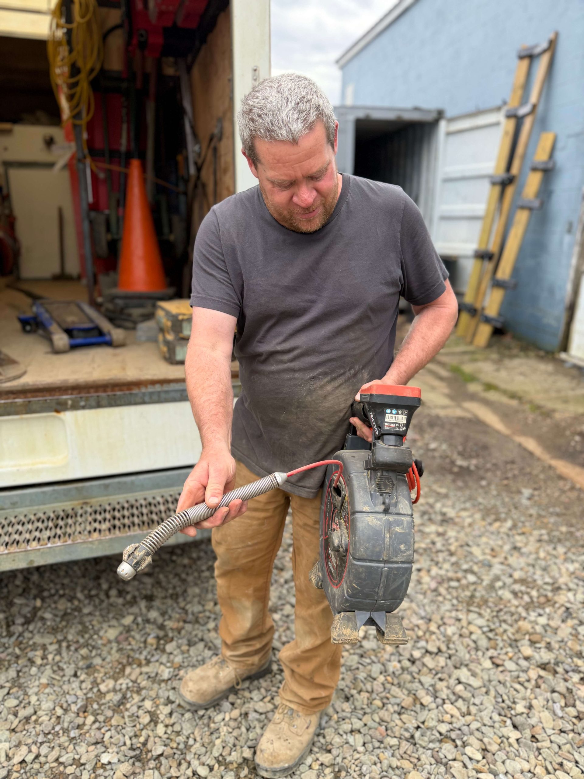 A McCandless Plumbing & Excavation worker prepares for a job, ready with tools and equipment for plumbing or excavation work.