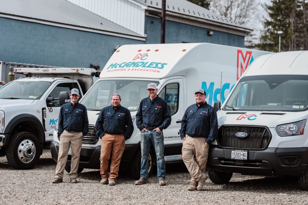 McCandless Plumbing & Excavation team members are happily ready to help, pictured together by their company vans.