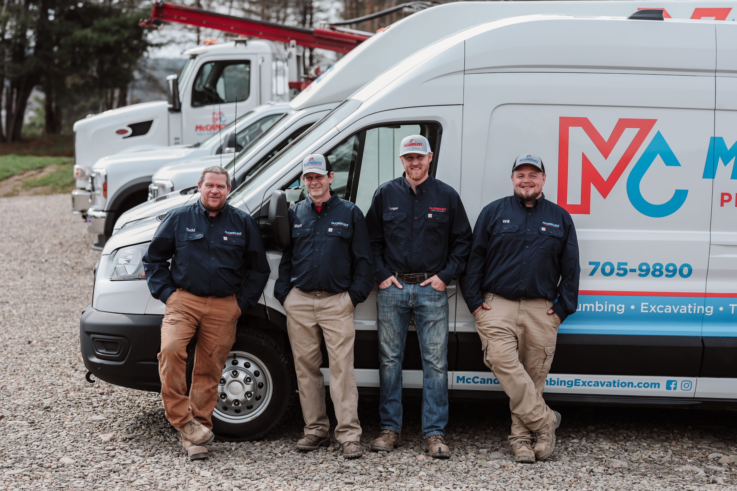 McCandless Plumbing & Excavation team members smiling together outside, showing pride in their company and services.